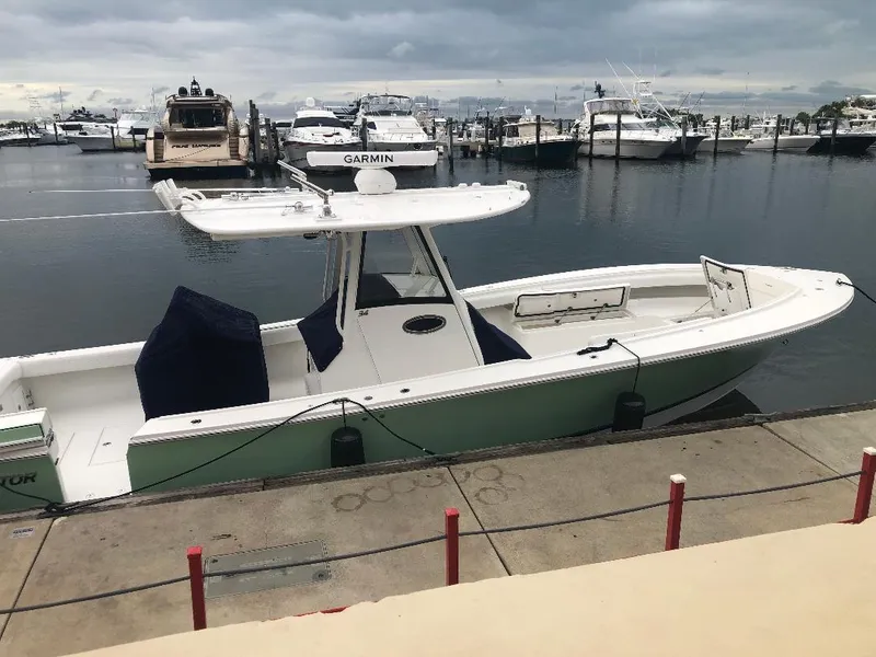 Slide: The Image of 2021 Regulator 34 Center Console boat docked at a marina under cloudy skies. - 5