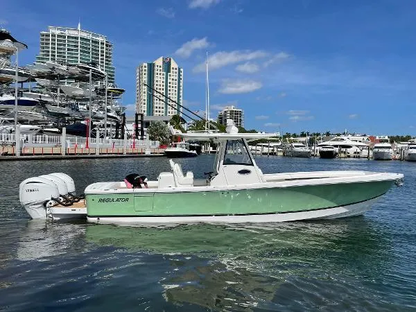 Slide: The Image of 2021 Regulator 34 Center Console boat docked in marina, clear sky background. - 7