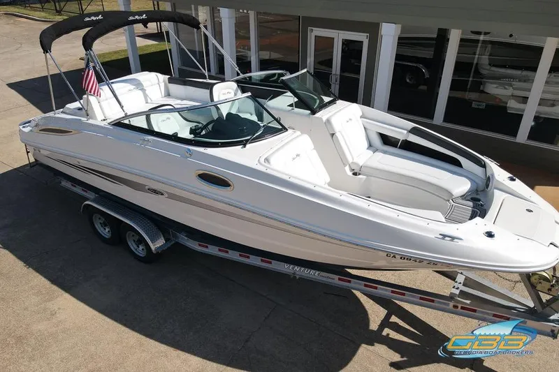 Slide: The Image of 2014 Sea Ray 260 Sundeck boat on trailer, white exterior, parked outdoors. - 11