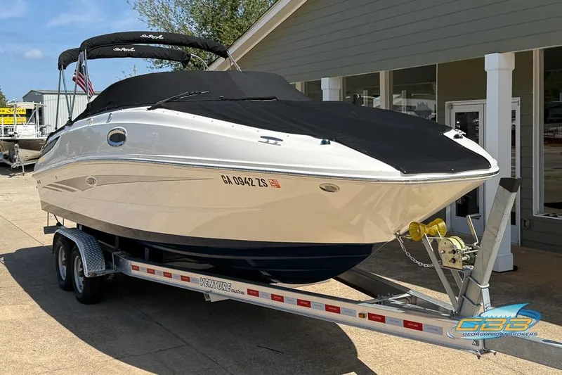 Slide: The Image of 2014 Sea Ray 260 Sundeck boat on trailer, covered and parked outside a building. - 15