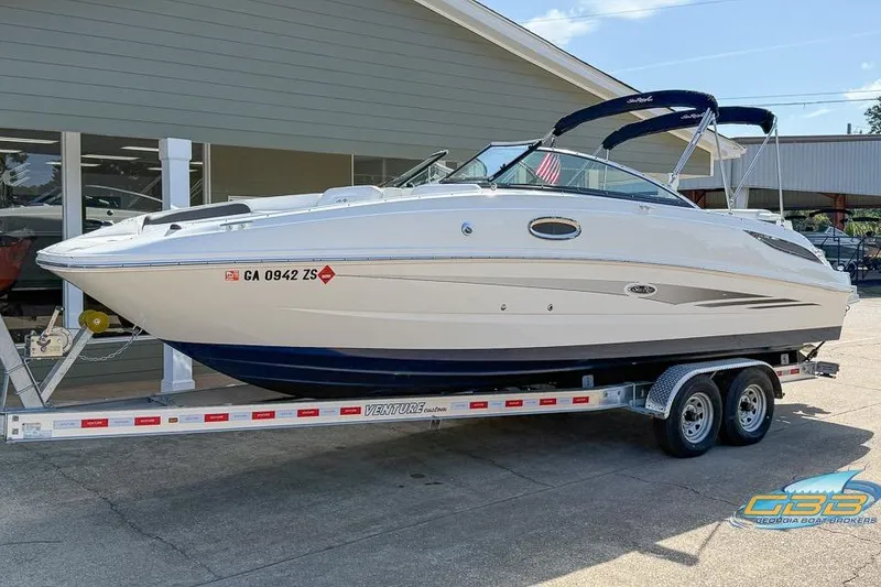 Slide: The Image of 2014 Sea Ray 260 Sundeck boat on trailer, parked outside a building. - 2
