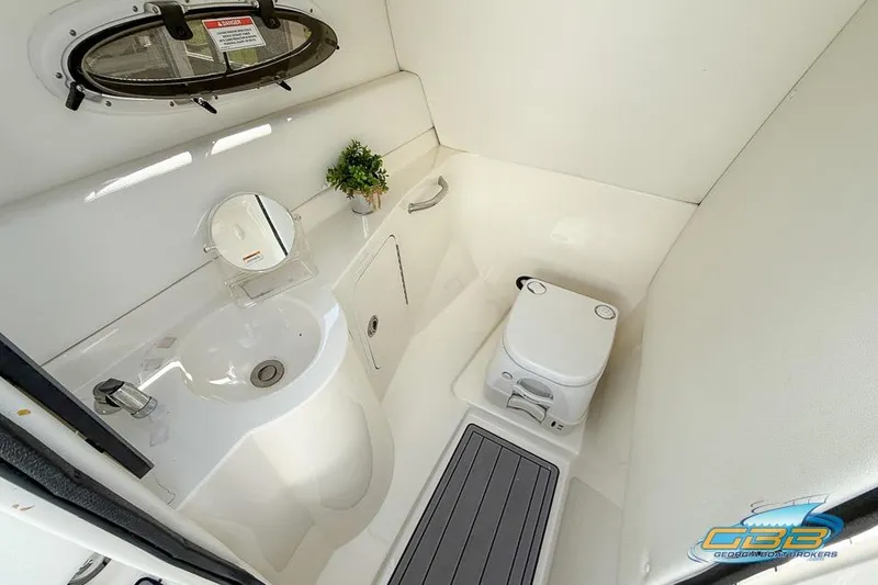 Slide: The Image of 2014 Sea Ray 260 Sundeck boat bathroom with sink, toilet, and porthole window. - 24