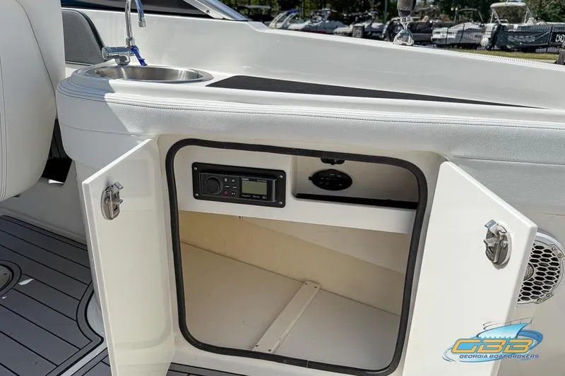 Slide: The Image of 2014 Sea Ray 260 Sundeck interior with open cabinet and sink. - 25