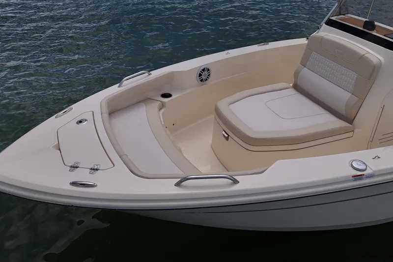 Slide: The Image of 2026 Scout 188 Sportfish boat with cushioned seating on calm water. - 11