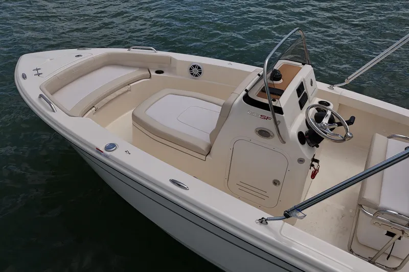 Slide: The Image of 2026 Scout 188 Sportfish boat interior with seating and steering console on water. - 13