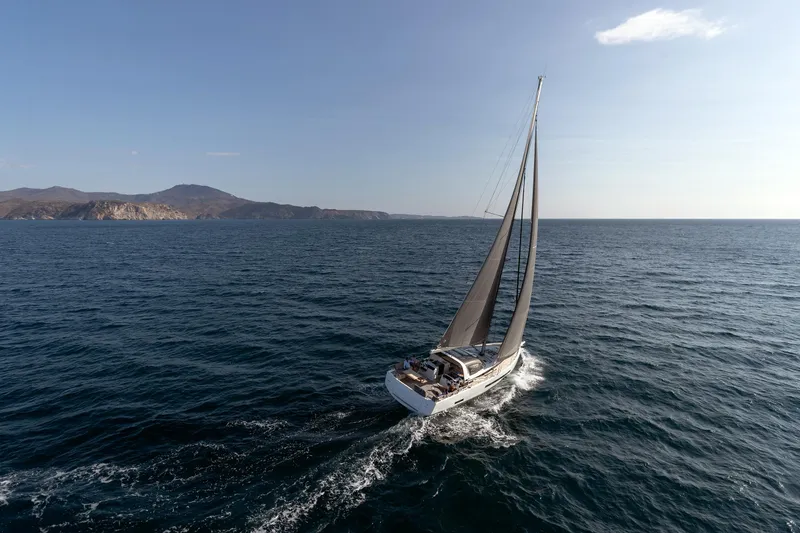 Slide: The Image of 2026 Jeanneau Yachts 55 sailing on open sea with distant coastline. - 2