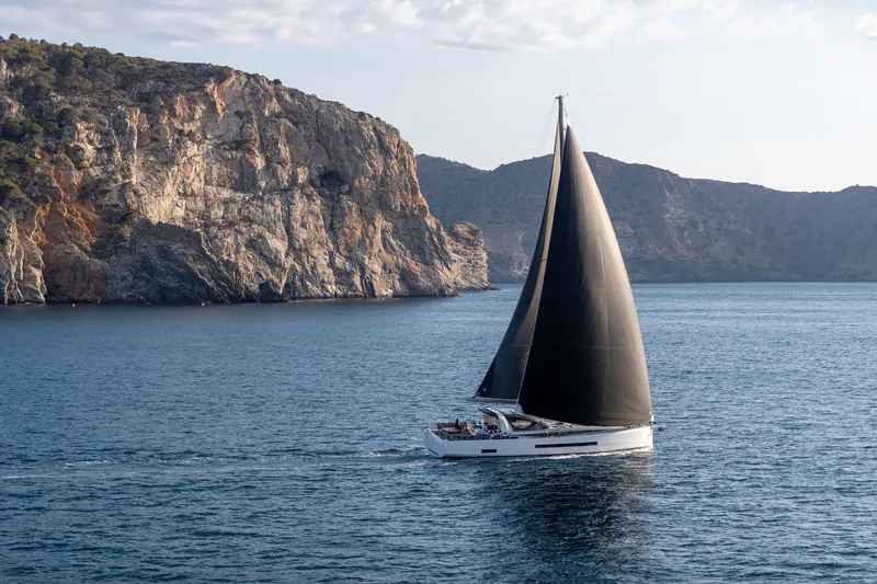 Slide: The Image of 2026 Jeanneau Yachts 55 sailing near rocky cliffs on a calm sea. - 5