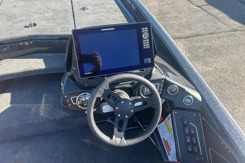 Slide: The Image of 2025 Skeeter ZXR21 boat dashboard with steering wheel and electronic display. - 12