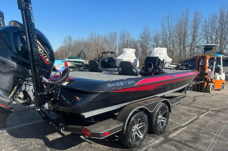 Slide: The Image of 2025 Skeeter ZXR21 boat on trailer, parked outdoors under clear blue sky. - 2