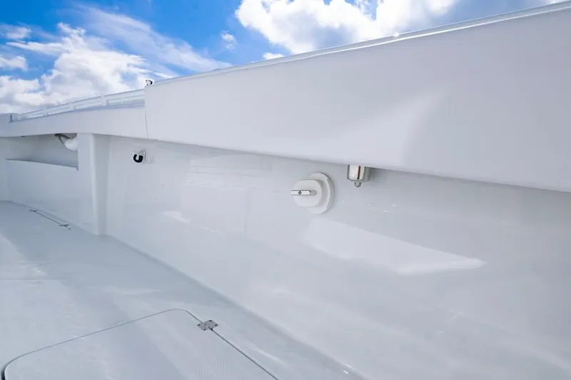 Slide: The Image of 2026 Invincible 33 Catamaran deck with sleek white finish under blue sky. - 24