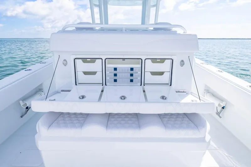 Slide: The Image of 2026 Invincible 33 Catamaran interior with storage compartments and seating, on calm ocean waters. - 30