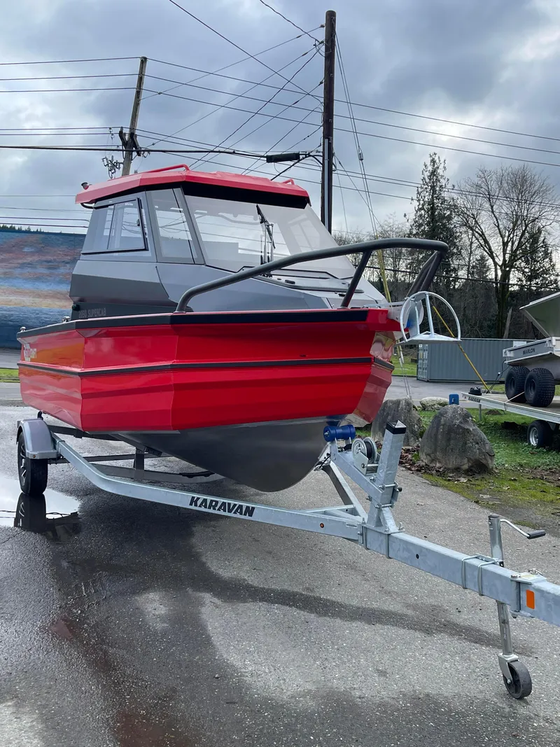 The Image of 2024 Stabicraft 2050 Supercab Sportfisher on trailer, red and gray design, outdoor setting. - 0