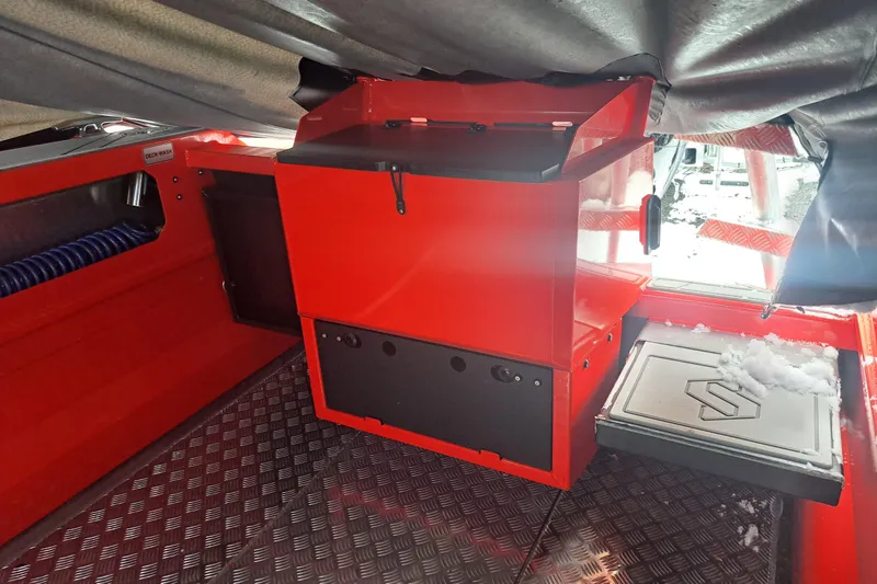 Slide: The Image of 2024 Stabicraft 2050 Supercab Sportfisher interior with red storage unit and snow-covered deck. - 2