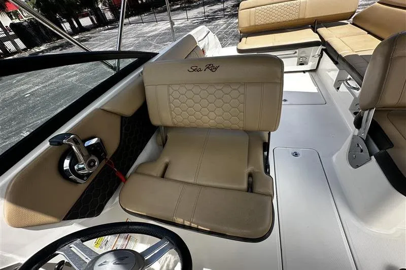 Slide: The Image of 2023 Sea Ray SDX 250 Outboard boat interior with tan seating and steering wheel. - 7
