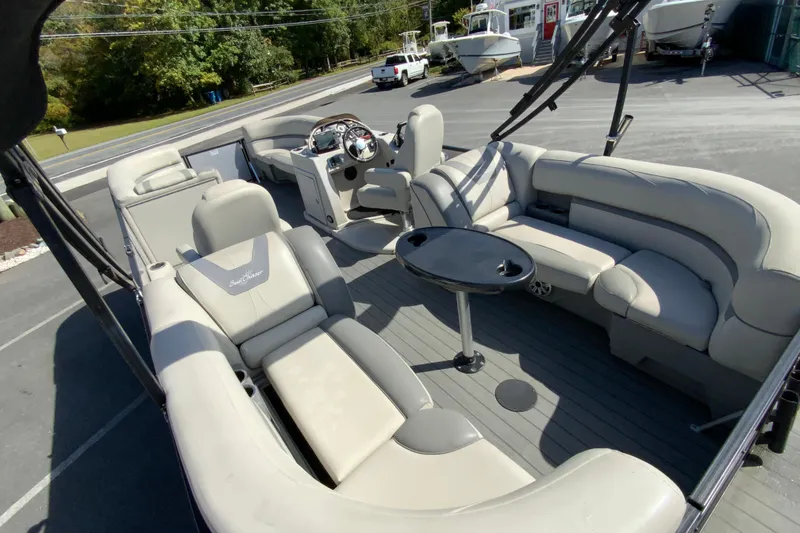 Slide: The Image of 2019 SunChaser Geneva Cruise 24 LR DH Sport pontoon boat interior with plush seating and steering console. - 11