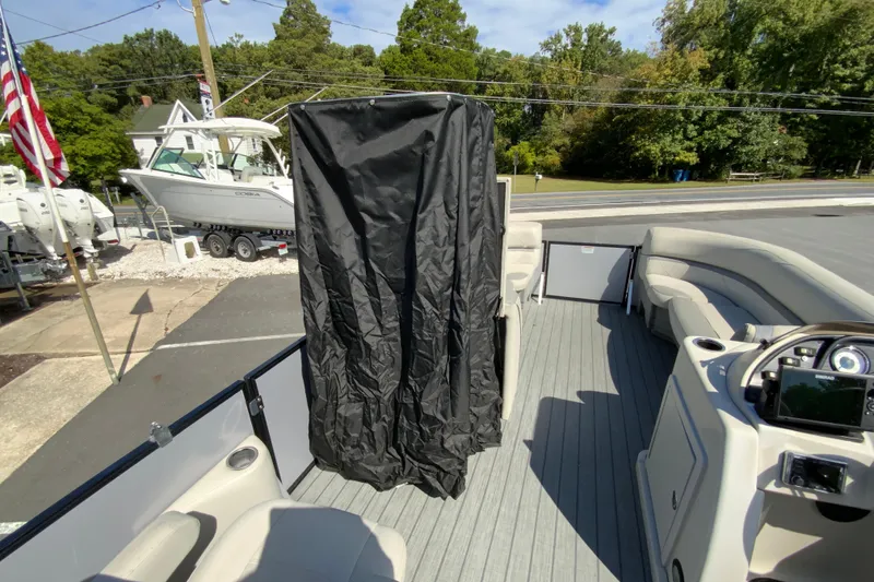 Slide: The Image of 2019 SunChaser Geneva Cruise 24 LR DH Sport pontoon boat interior with seating and console. - 22