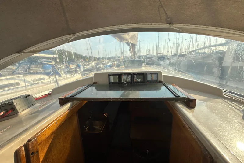 Slide: The Image of Interior view of 1985 Dehler 372 sailboat cockpit with marina background. - 13