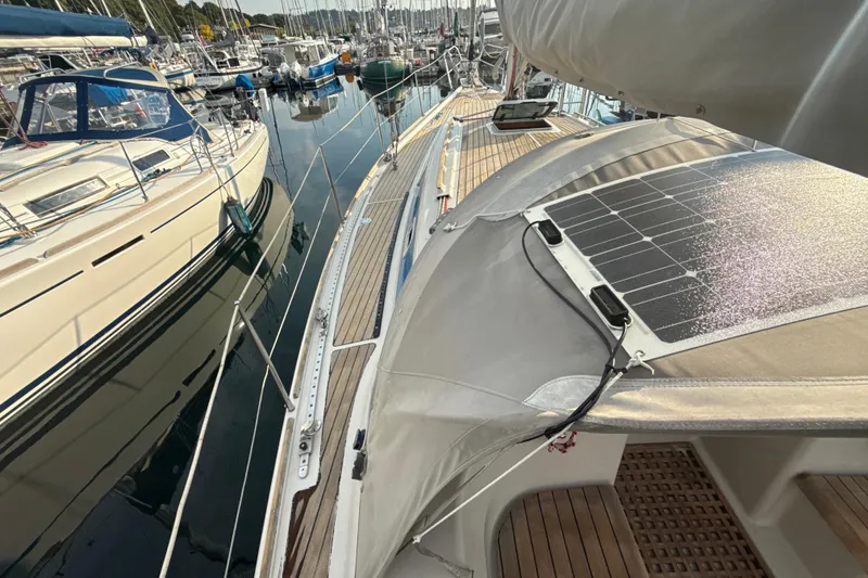 Slide: The Image of 1985 Dehler 372 sailboat with solar panel, docked among other boats. - 18