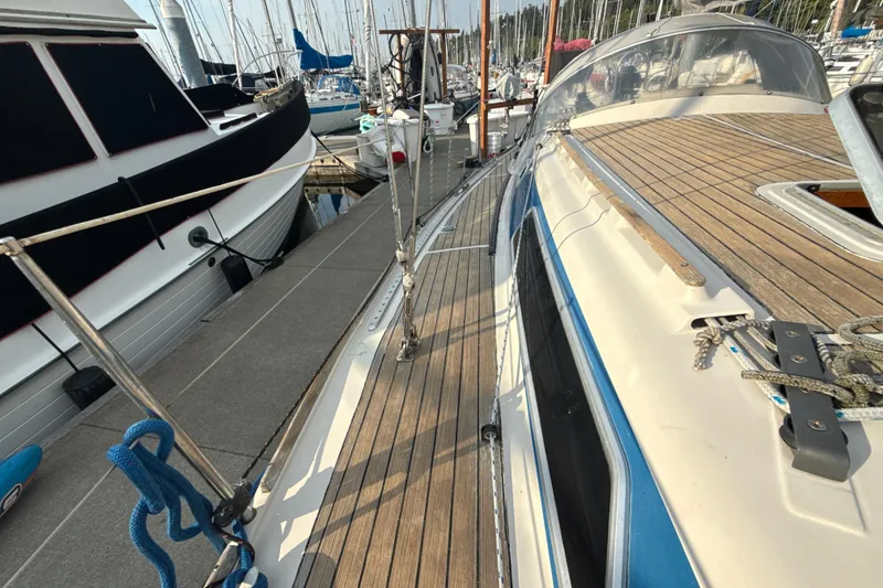Slide: The Image of 1985 Dehler 372 sailboat docked at marina, showcasing teak deck and sleek design. - 21