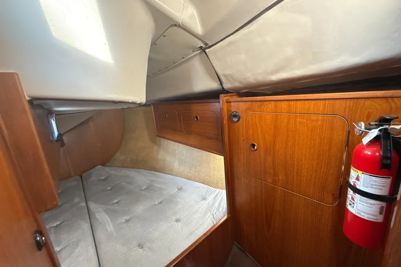 Slide: The Image of Cozy cabin interior of 1985 Dehler 372 sailboat with wooden paneling and fire extinguisher. - 23