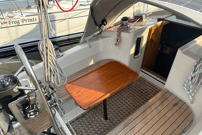 Slide: The Image of Cockpit of 1985 Dehler 372 sailboat with wooden table and nautical equipment. - 3