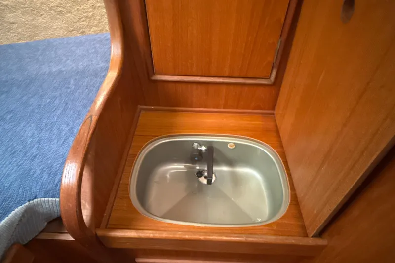 Slide: The Image of 1985 Dehler 372 yacht interior with wooden cabinetry and compact sink. - 31