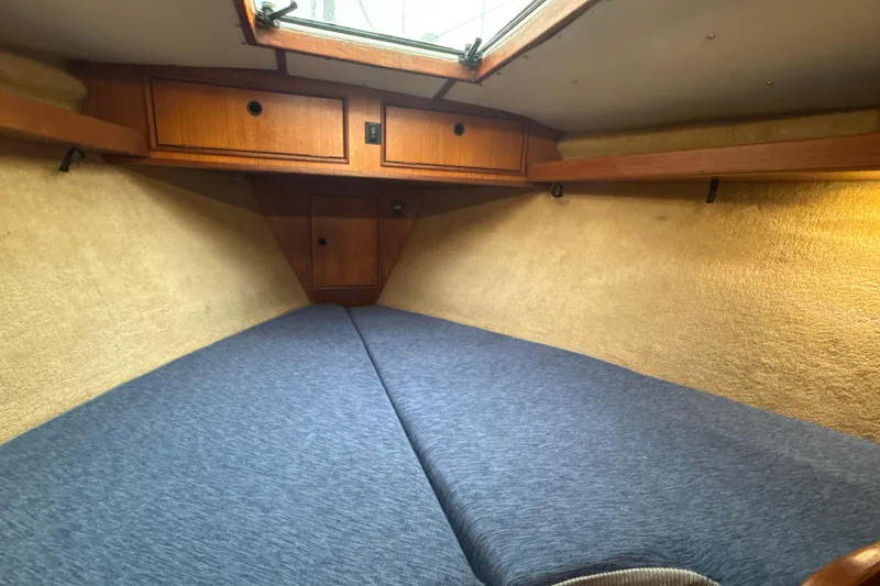 Slide: The Image of Cozy cabin interior of 1985 Dehler 372 sailboat with blue bedding and wooden storage. - 33