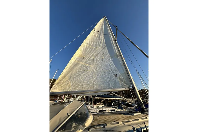 Slide: The Image of 1985 Dehler 372 sailboat with full sails against a clear blue sky. - 47