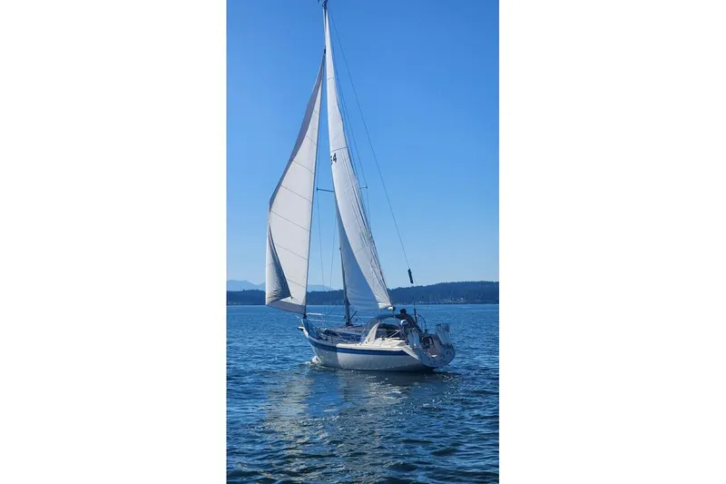 Slide: The Image of 1985 Dehler 372 sailboat gliding on calm blue waters under clear skies. - 48