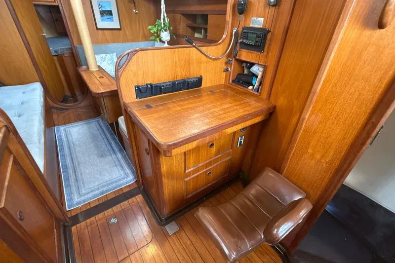 Slide: The Image of 1985 Dehler 372 yacht interior with wooden navigation station and seating. - 8