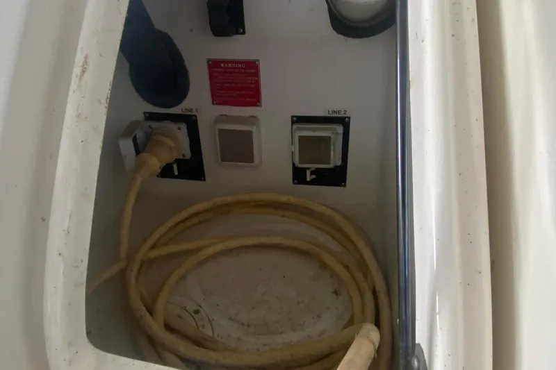 Slide: The Image of Electrical connections and coiled cable in a 2004 Regal Commodore 3560 boat compartment. - 13