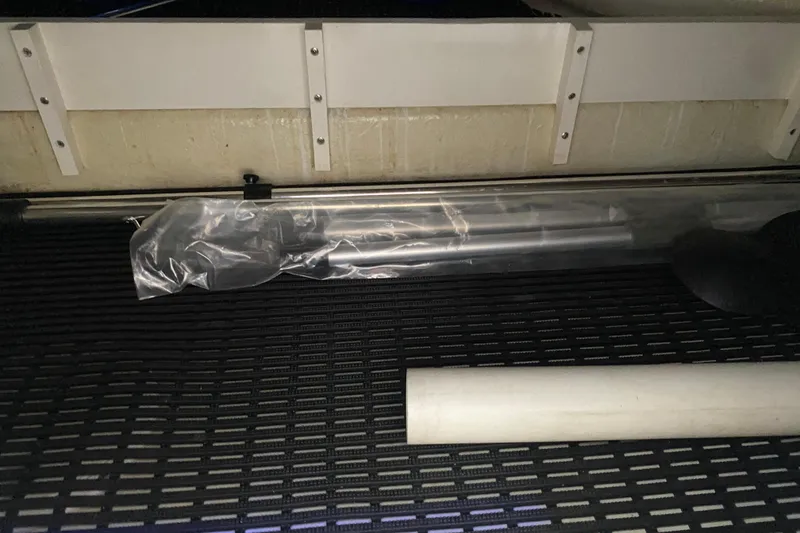 Slide: The Image of Storage compartment in a 2004 Regal Commodore 3560 boat, featuring wrapped items and a white pipe. - 44