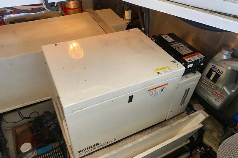 Slide: The Image of Engine room of 2004 Regal Commodore 3560 with Kohler power system and Mobil oil container. - 48