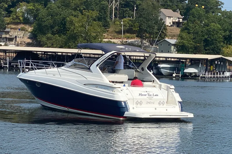 Slide: The Image of 2004 Regal Commodore 3560 boat cruising on a lake near docks and trees. - 5