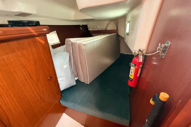 Slide: The Image of Interior cabin of 2001 Beneteau 361 sailboat with fire extinguisher and cushions. - 13