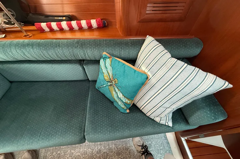 Slide: The Image of Interior of 2001 Beneteau 361 sailboat with teal cushions and decorative pillows. - 16