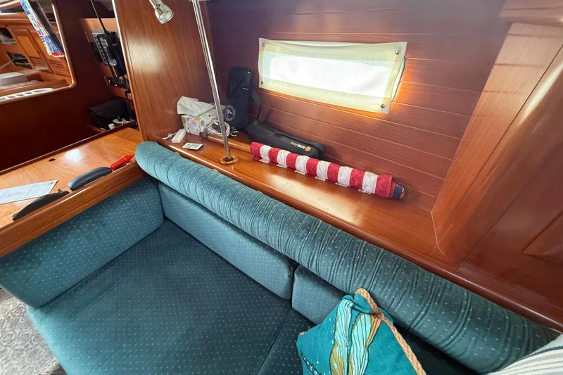 Slide: The Image of Interior of 2001 Beneteau 361 sailboat with teal seating and wooden accents. - 17