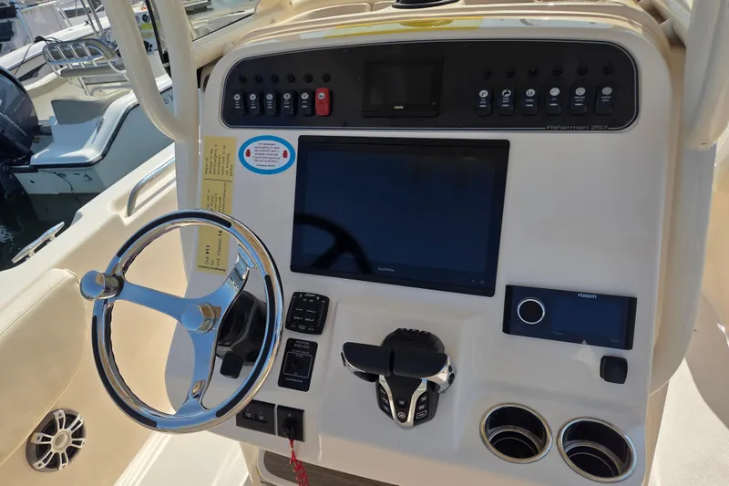 Slide: The Image of Control panel of 2025 Grady-White Fisherman 257 boat with steering wheel and electronic displays. - 13