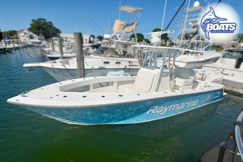 Slide: The Image of 2022 SeaVee 290B boat docked in a marina, surrounded by other vessels. - 0