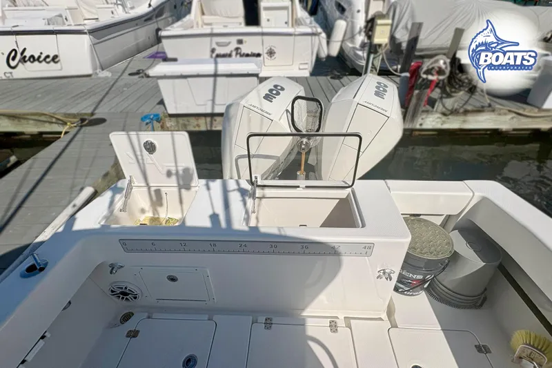 Slide: The Image of 2022 SeaVee 290B boat with open storage compartments and fishing gear setup. - 12