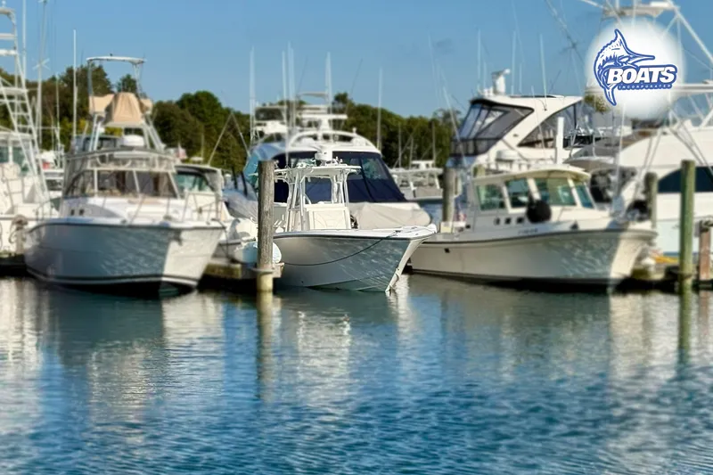 Slide: The Image of 2022 SeaVee 290B boat docked among other vessels in a marina. - 2