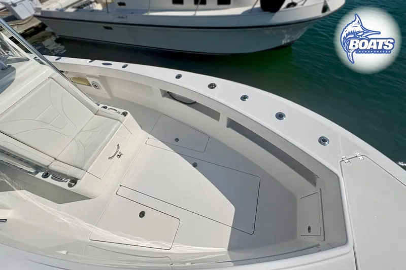 Slide: The Image of 2022 SeaVee 290B boat deck with seating and storage, docked near another vessel. - 4