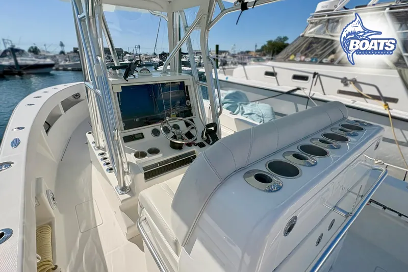 Slide: The Image of 2022 SeaVee 290B boat interior with helm, rod holders, and marina background. - 8
