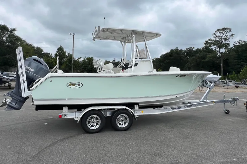 Slide: The Image of 2016 Sea Hunt Ultra 225 boat on trailer with Yamaha engine, parked outdoors. - 1