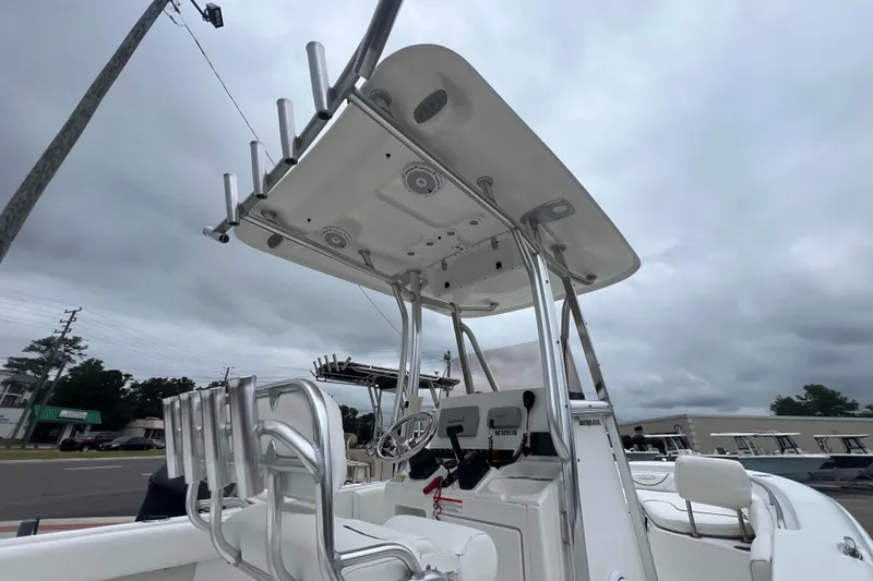 Slide: The Image of 2016 Sea Hunt Ultra 225 boat with T-top and rod holders under cloudy sky. - 11