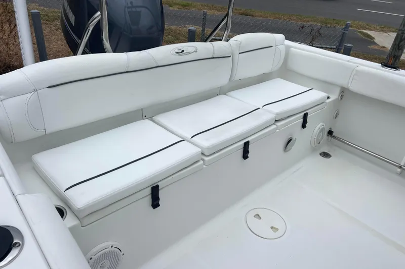 Slide: The Image of 2016 Sea Hunt Ultra 225 boat interior with white cushioned seating. - 12