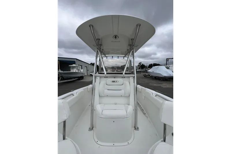 Slide: The Image of 2016 Sea Hunt Ultra 225 boat interior with T-top and seating, under cloudy sky. - 7