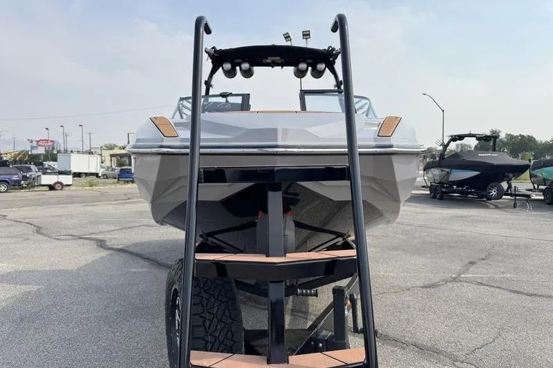 Slide: The Image of 2023 Supra SL boat on trailer, front view in parking lot. - 4