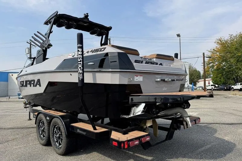 Slide: The Image of 2023 Supra SL boat on trailer, showcasing sleek design and dual-axle wheels. - 6