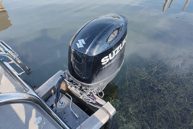Slide: The Image of 2023 Paradise Pontoon Tritoon with Suzuki outboard motor on calm water. - 2